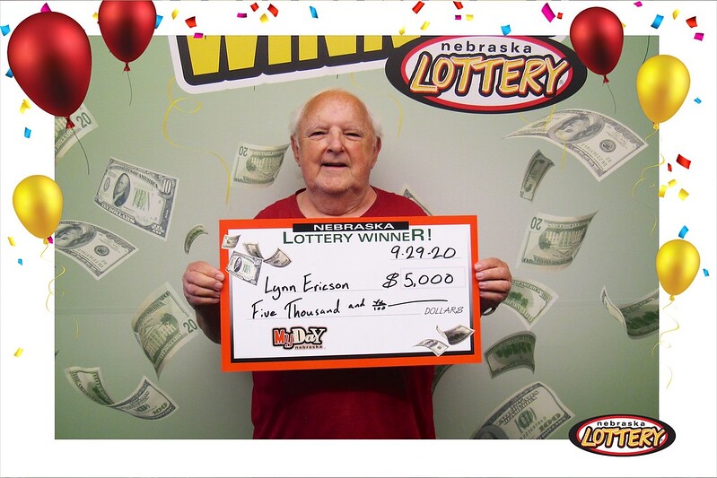 Lynn Ericson with a large check for $5,000 he won playing MyDaY.