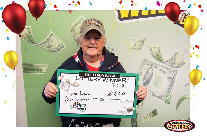 Lynn Ericson holding a big check for $600 he won on Pick 3. 